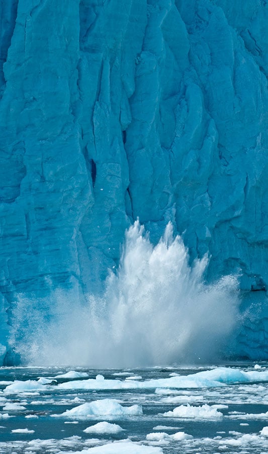 A falling piece of glacier splashes in the waters of Glacier Bay